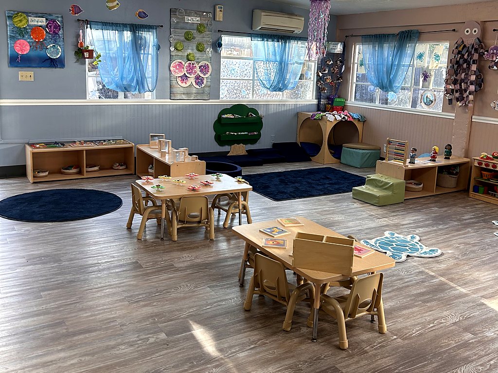 Toddler classroom for 1-year-olds at a Small Miracles daycare in Tucson with low shelves, small tables and soft reading spaces